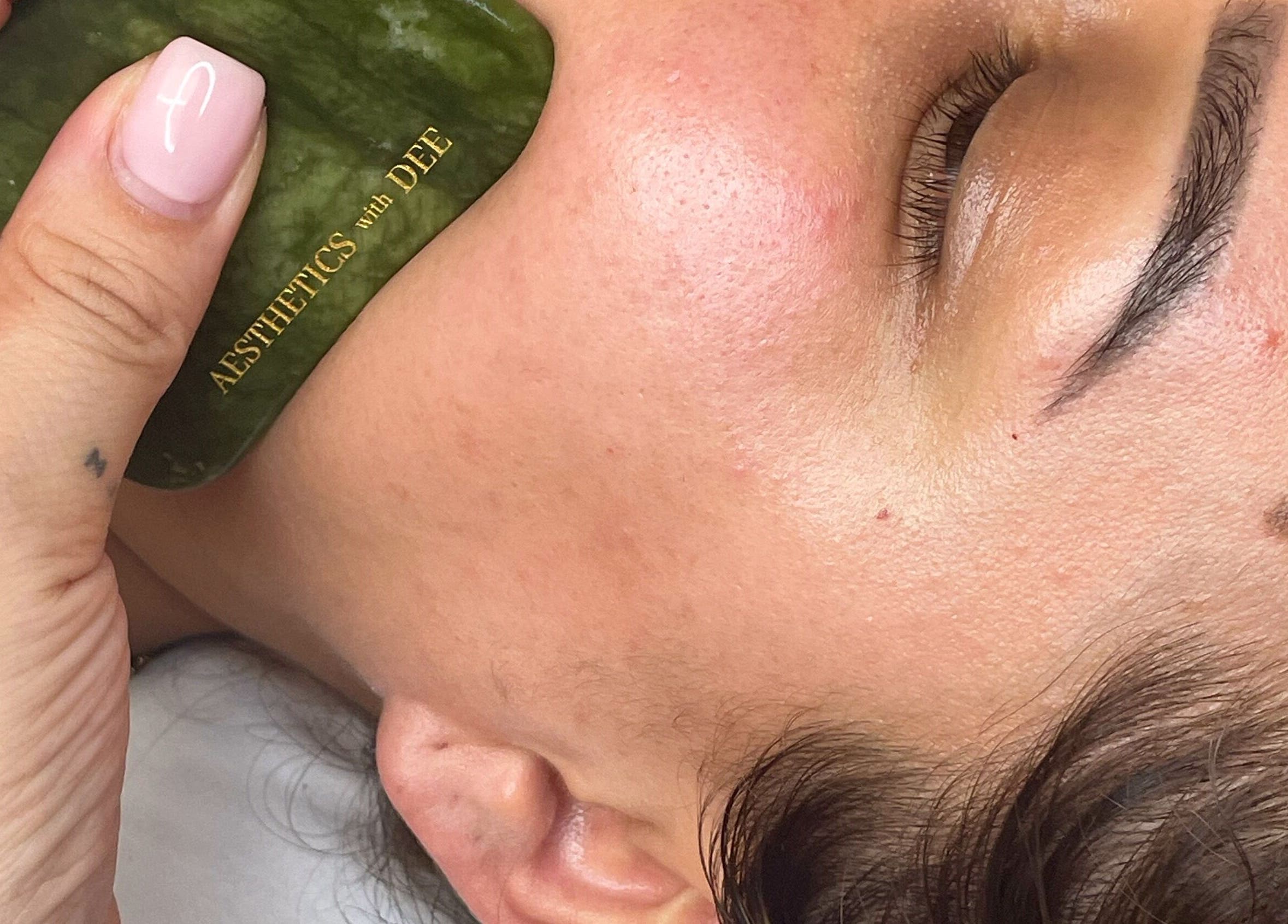 Facial massage using jade stone at Aesthetics with Dee, London, England, GB enhances skin glow.