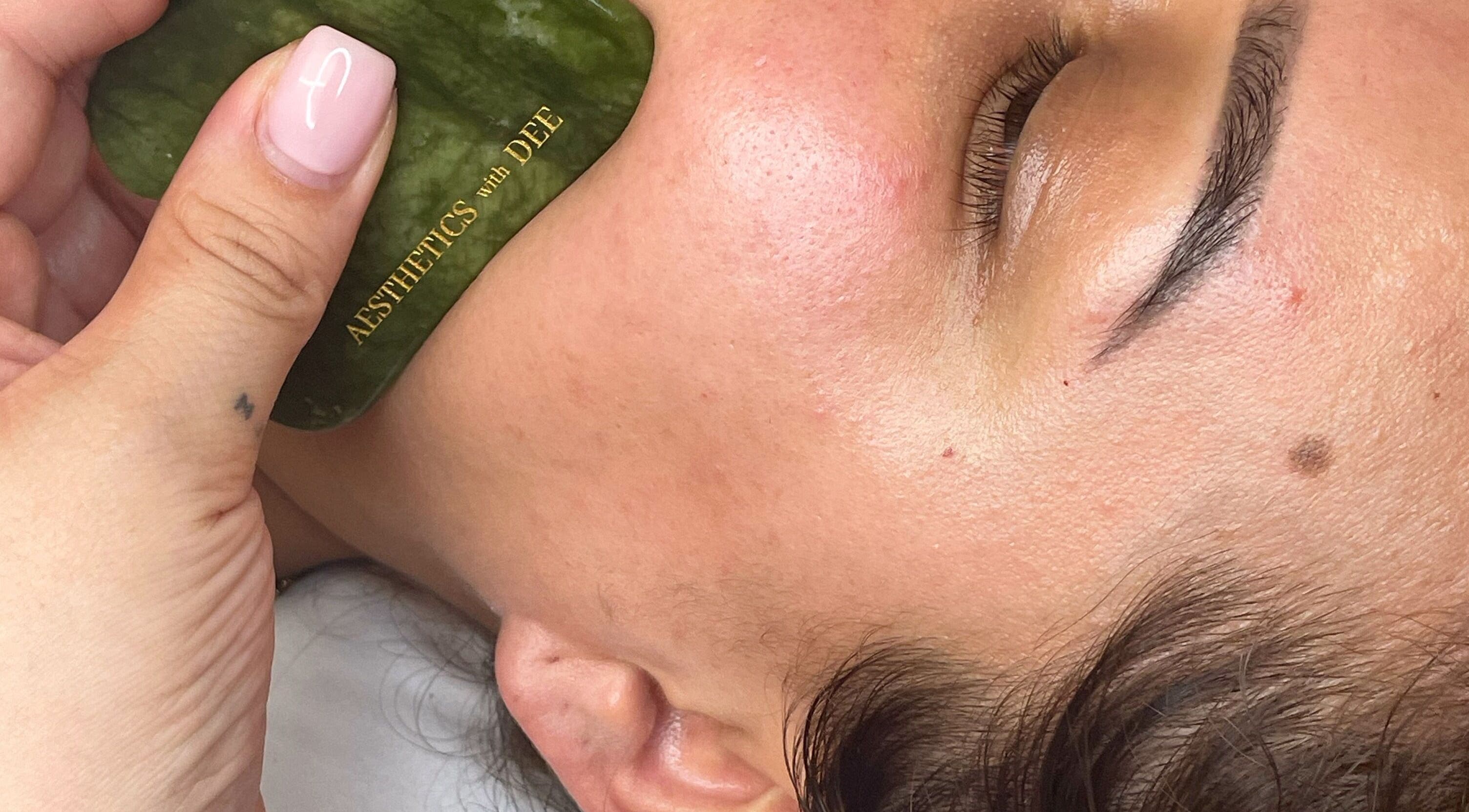 Facial massage using jade stone at Aesthetics with Dee, London, England, GB enhances skin glow.