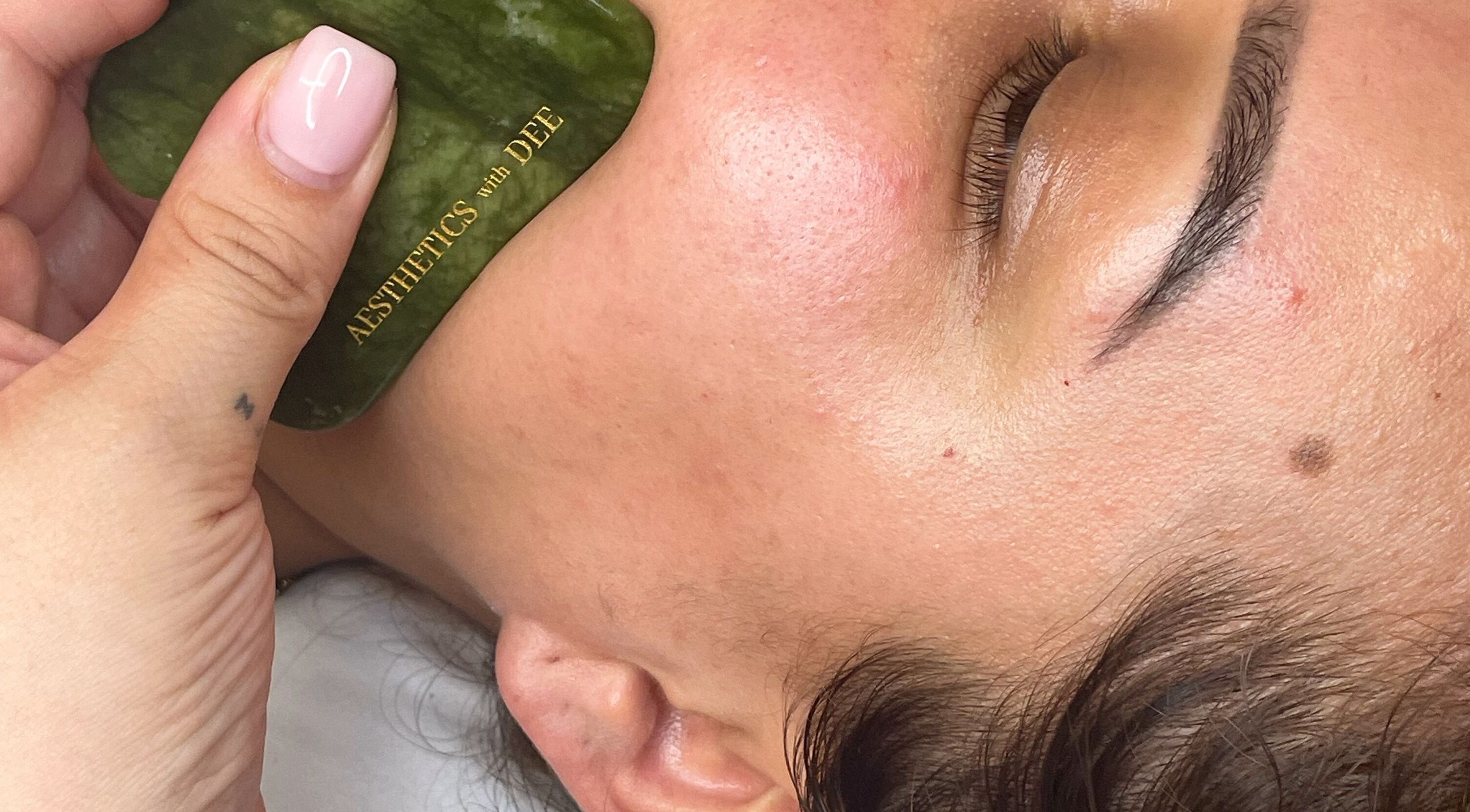Facial massage using jade stone at Aesthetics with Dee, London, England, GB enhances skin glow.