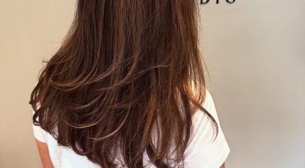 Stylish layered haircut at The Olive Room, Newbury, England, GB showcasing smooth, glossy brown hair.