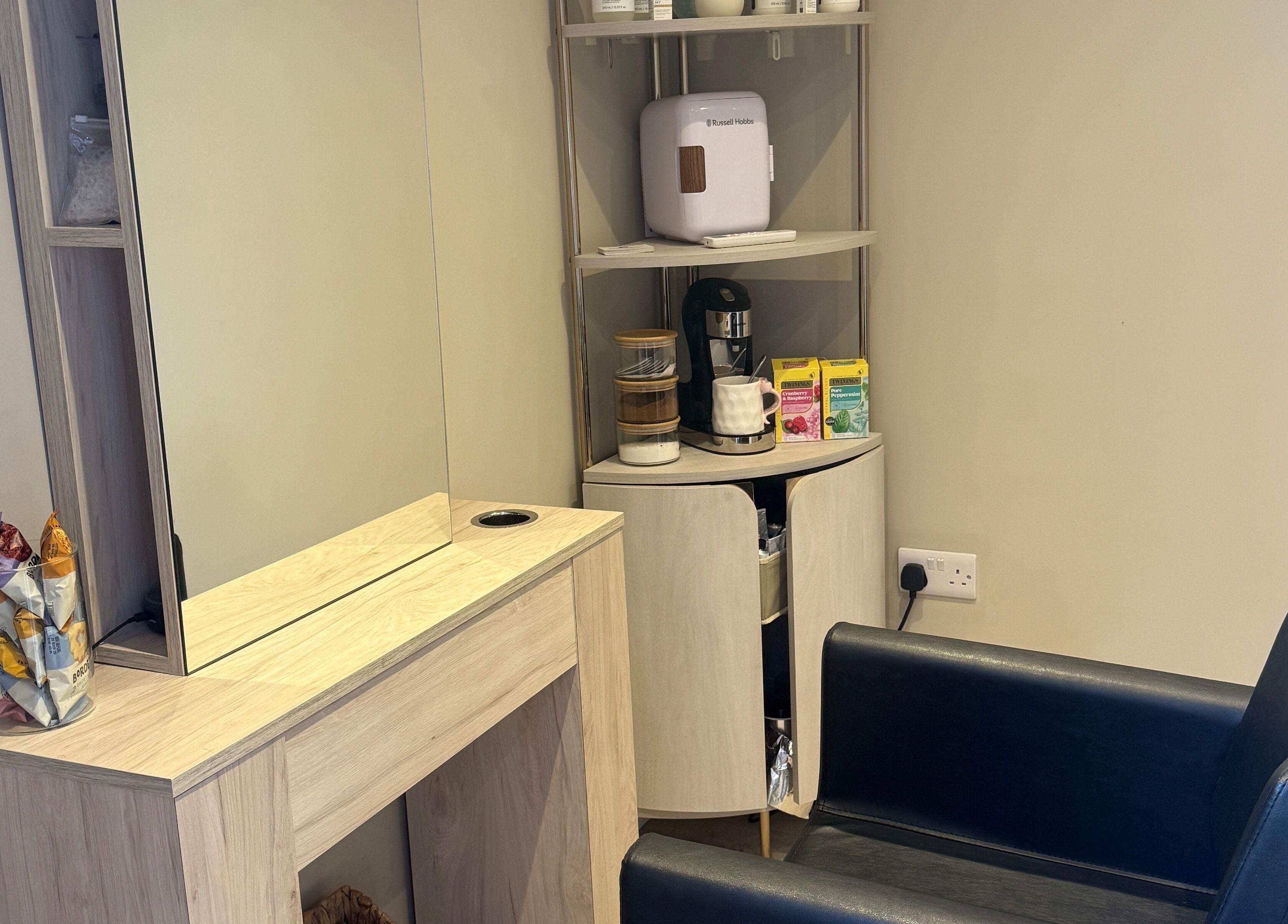 Elegant corner at The Olive Room in Newbury, England, GB, featuring a mirror and refreshments for relaxation.