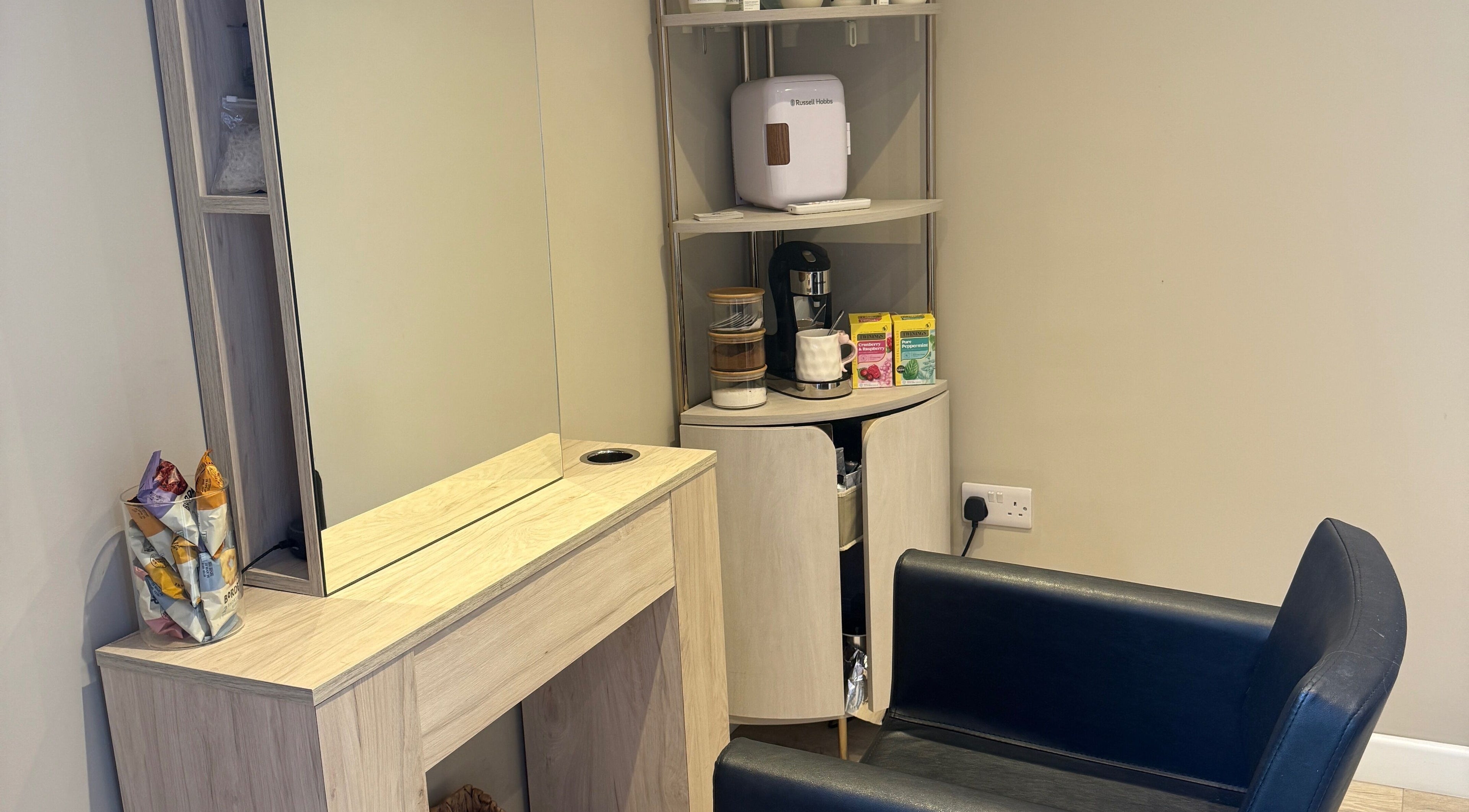 Elegant corner at The Olive Room in Newbury, England, GB, featuring a mirror and refreshments for relaxation.