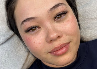 Close-up of a woman with radiant skin and eyelash extensions at Johnny's Makeover Home Salon, Rothwell, Queensland, AU.