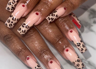 Stylish leopard print manicure with red gems at Naild By Tee, Chicago Heights, Illinois, US.