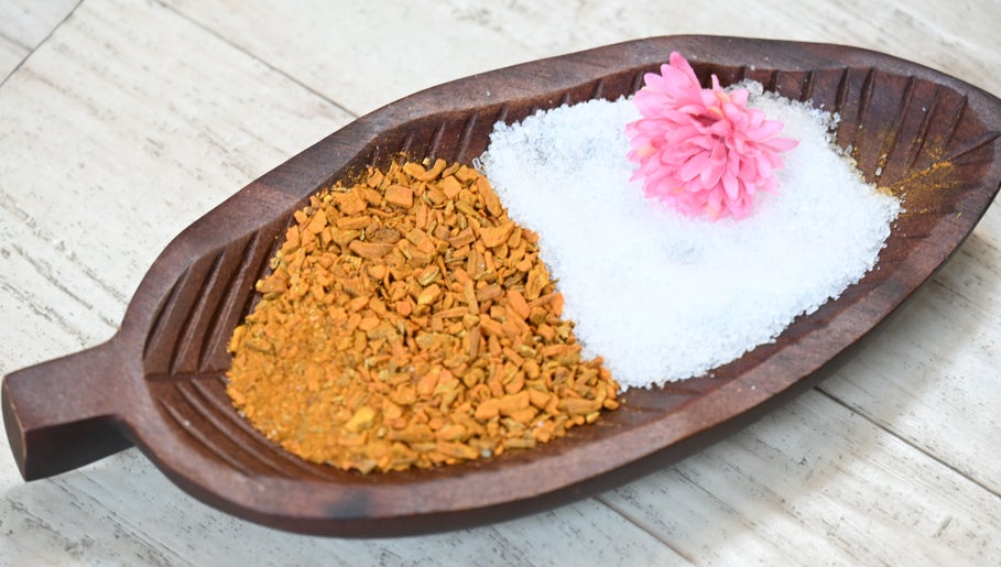 Herbal and salt spa dish at Thai House Wellness and Spa, Sacramento, California, US with pink flower accent.