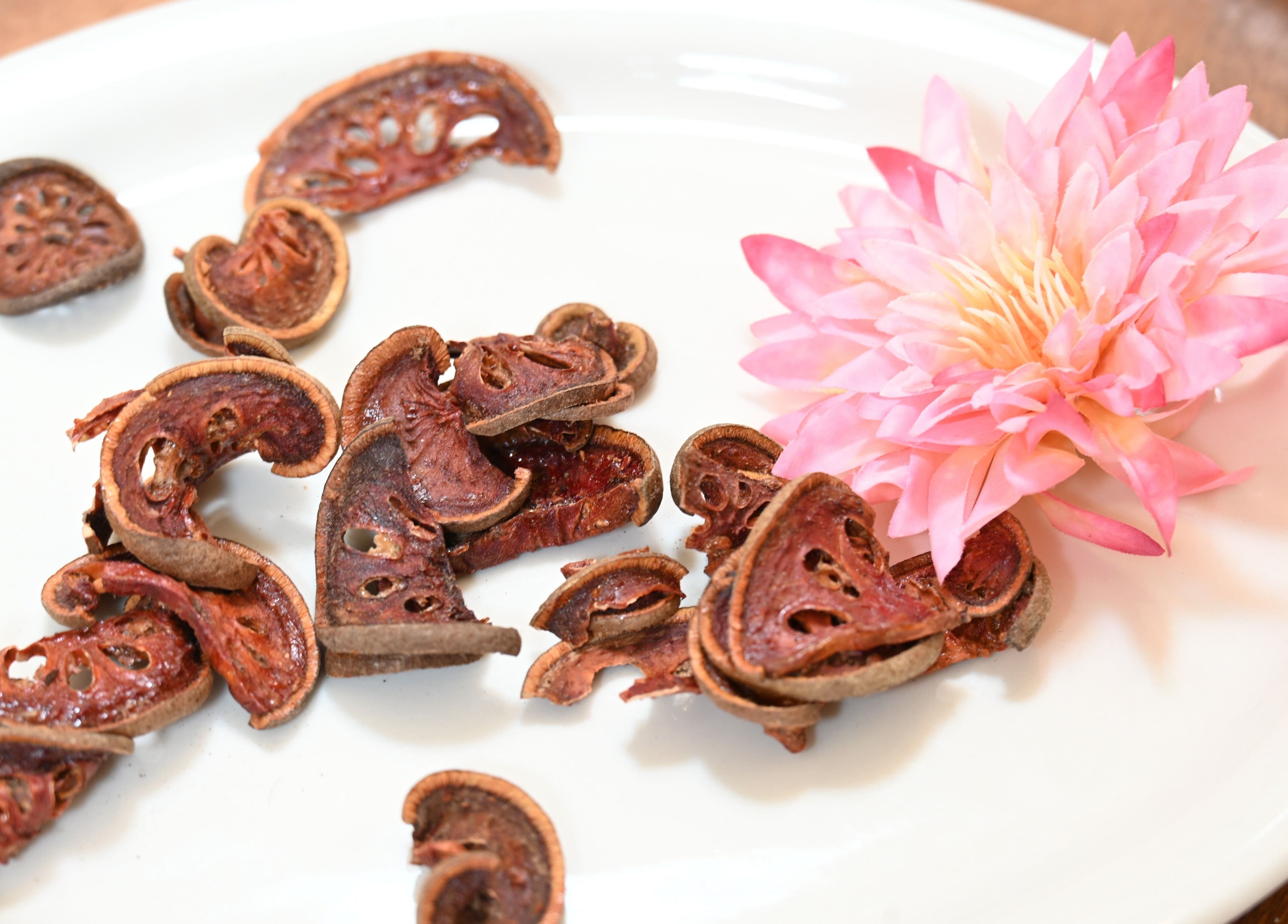 Dried fruits and vibrant pink flower on a plate at Thai House Wellness and Spa, Sacramento, California, US.