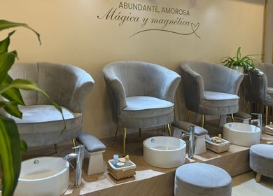Área de pedicura en ESSENCIAL SPA DE UÑAS Y ESTETICA FACIAL, Cali, Valle Del Cauca, CO con sillas grises elegantes.
