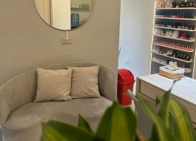 Rincón acogedor de ESSENCIAL SPA DE UÑAS Y ESTETICA FACIAL en Cali, Valle Del Cauca, CO, con sofá y estantería.