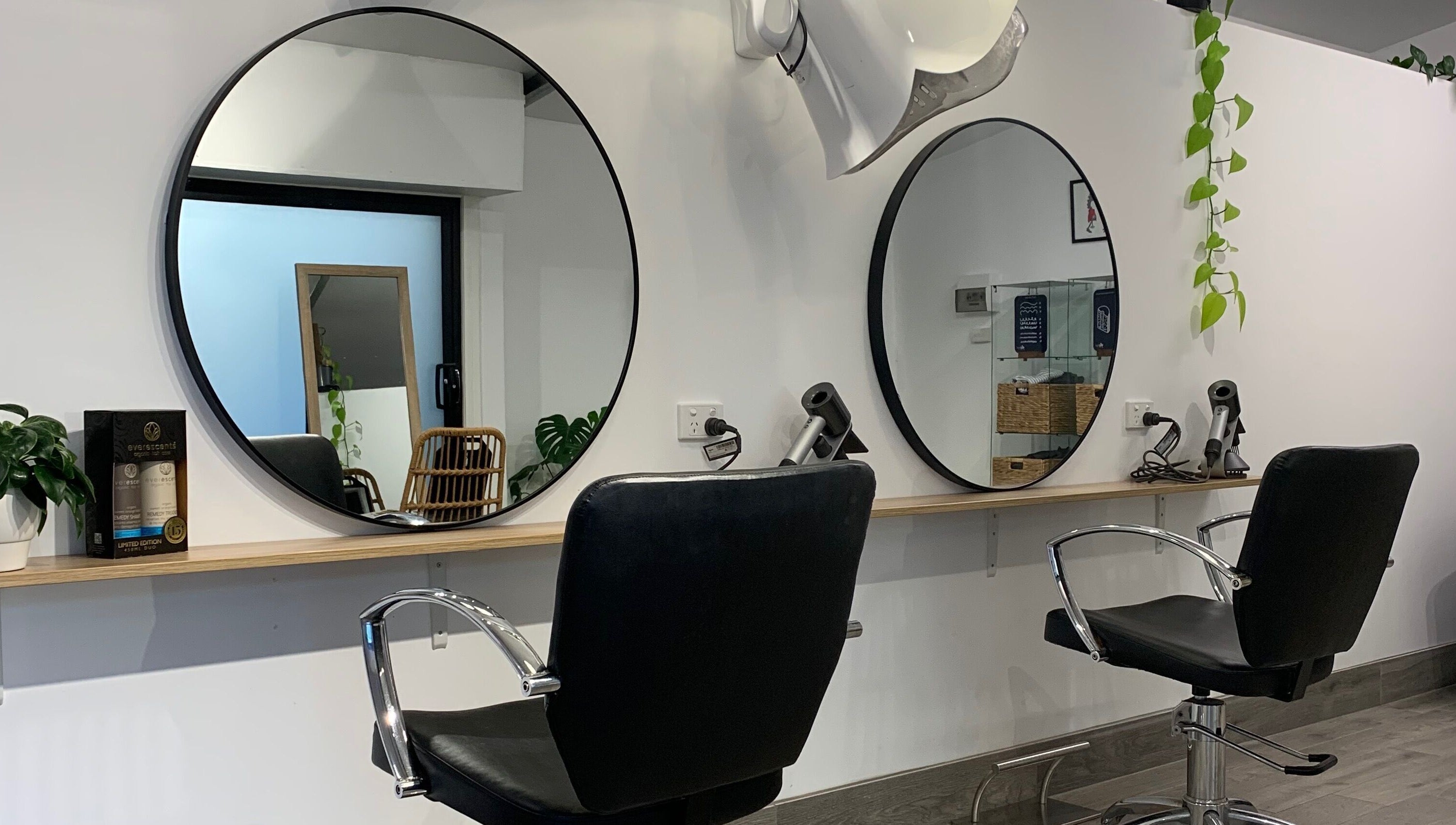 Modern salon interior at Studio Hi Gorgeous, Alfredton, Victoria, AU, featuring sleek design and round mirrors.