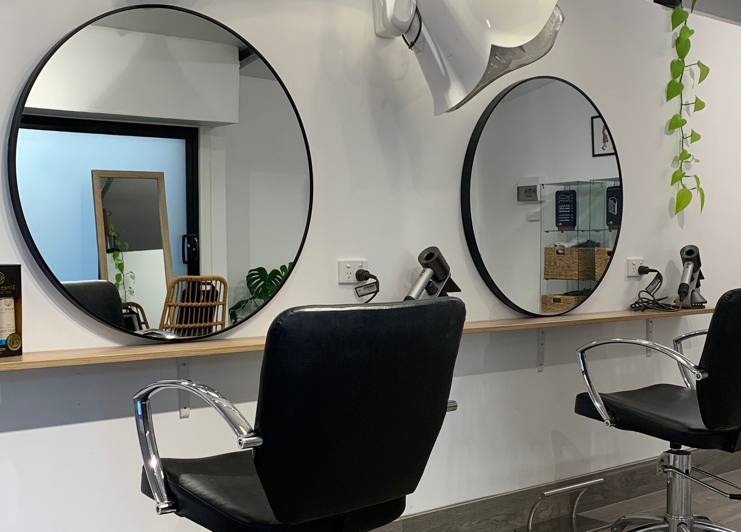 Modern salon interior at Studio Hi Gorgeous, Alfredton, Victoria, AU, featuring sleek design and round mirrors.