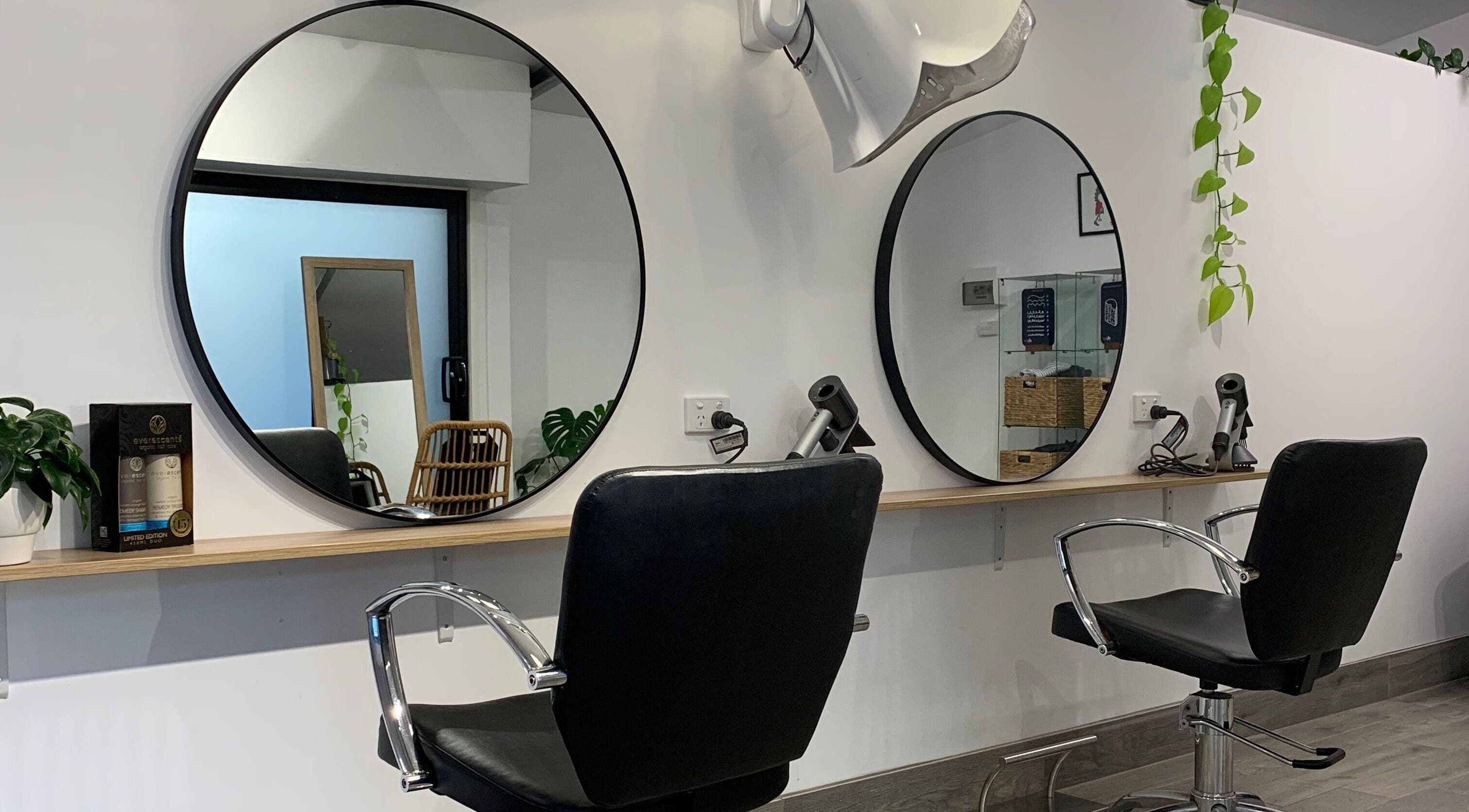 Modern salon interior at Studio Hi Gorgeous, Alfredton, Victoria, AU, featuring sleek design and round mirrors.