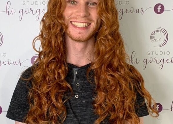 Smiling client with long, flowing red curls at Studio Hi Gorgeous, Alfredton, Victoria, AU.
