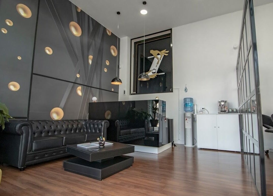 Elegante recepción de ZNails en Jerez De La Frontera, Andalucía, ES, decorada con sofás oscuros y arte moderno.