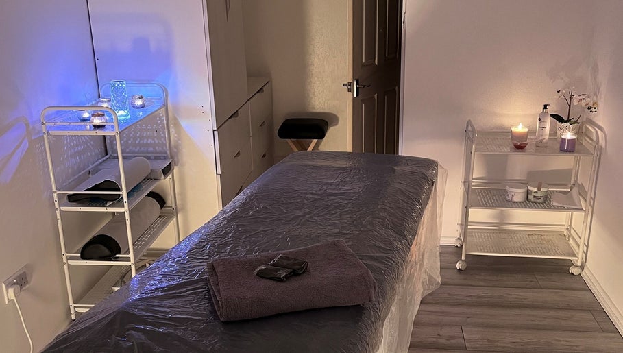 Serene massage room at Palmarys in Southampton, England, GB with cozy ambience and candles for relaxation.