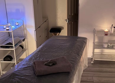 Serene massage room at Palmarys in Southampton, England, GB with cozy ambience and candles for relaxation.