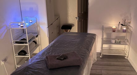 Serene massage room at Palmarys in Southampton, England, GB with cozy ambience and candles for relaxation.