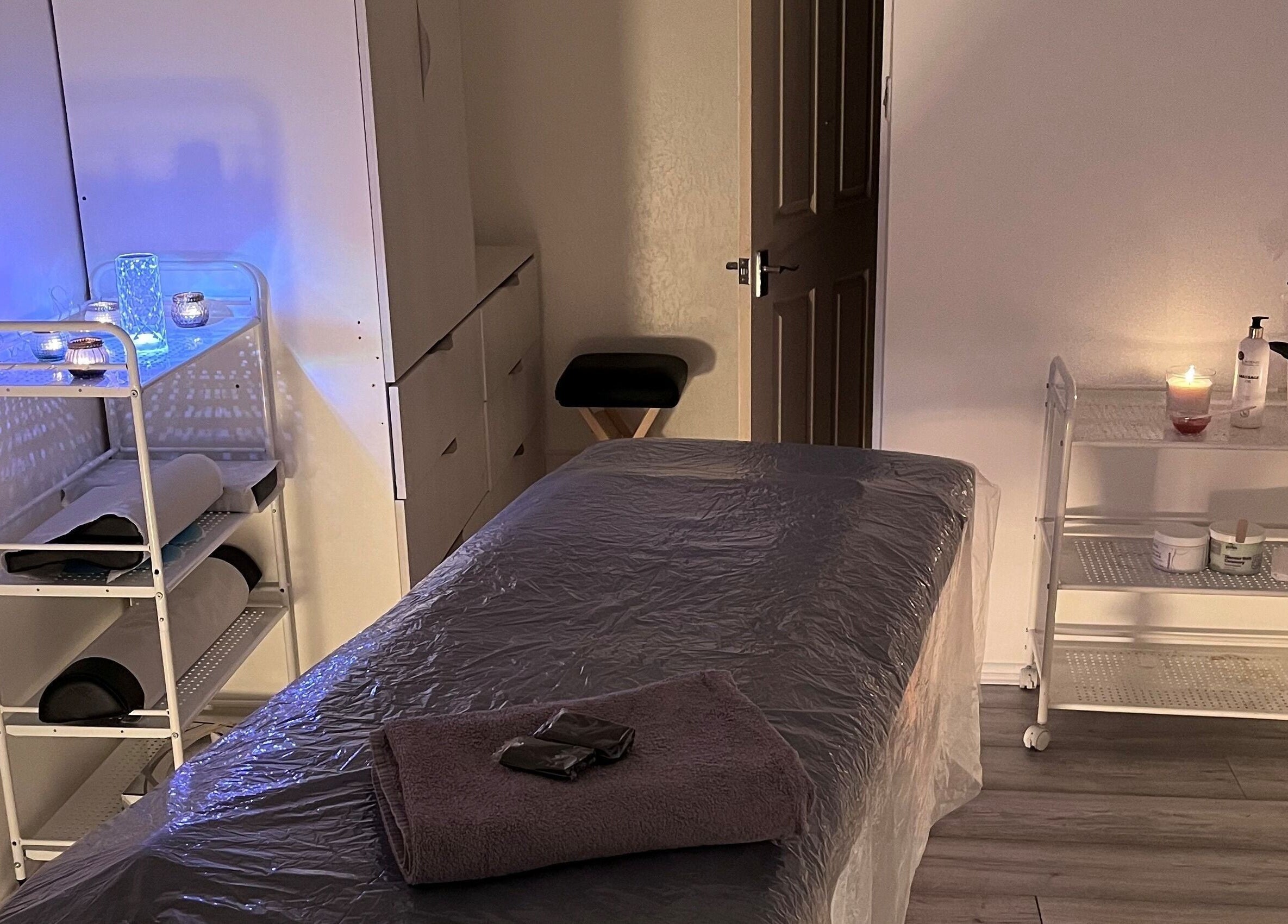 Cozy treatment room at Palmarys, Southampton, England, GB, featuring a massage table and soothing ambiance.