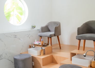 Relaxing pedicure stations at Anatolly Beauty Salon, Bali, Bali, ID, with plush gray chairs and marble decor.