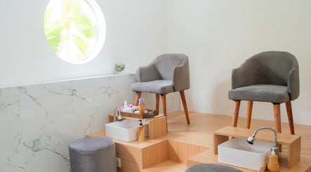 Relaxing pedicure stations at Anatolly Beauty Salon, Bali, Bali, ID, with plush gray chairs and marble decor.