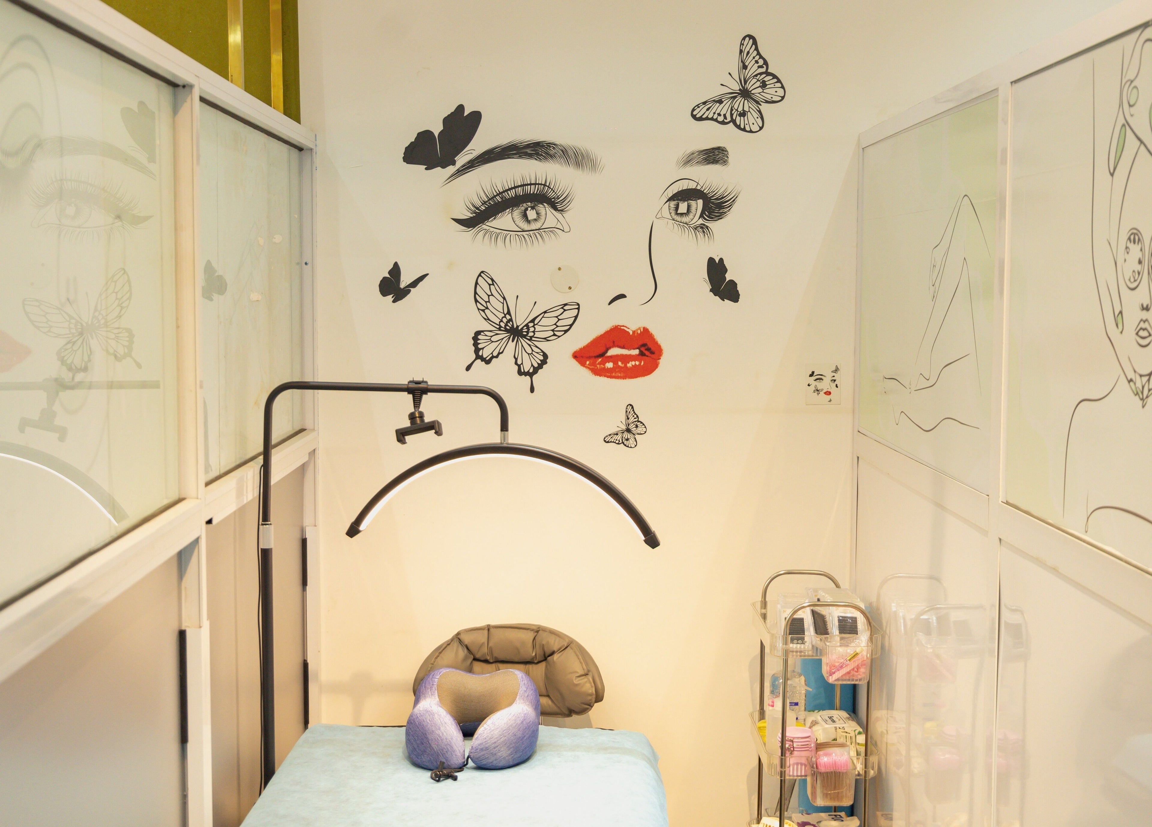 A calming treatment room at Styeeze Spa and Health Club in Greater Accra Region, GH with wall art of a face with butterflies.