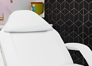 Modern treatment chair at Harley Beauty Aesthetic Clinic, Ilford, England, GB with stylish black and gold decor.