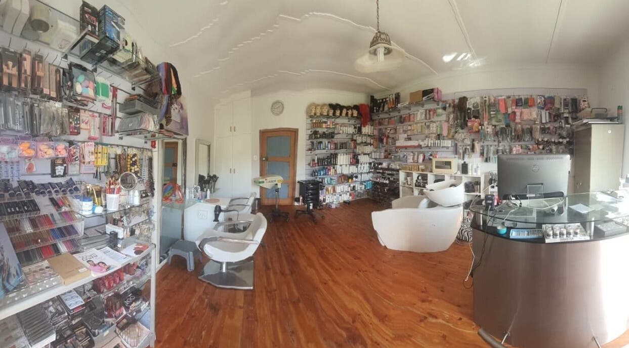 Interior view of Yve's Salon, Darling, ZA showcasing modern styling chairs and vibrant product displays.