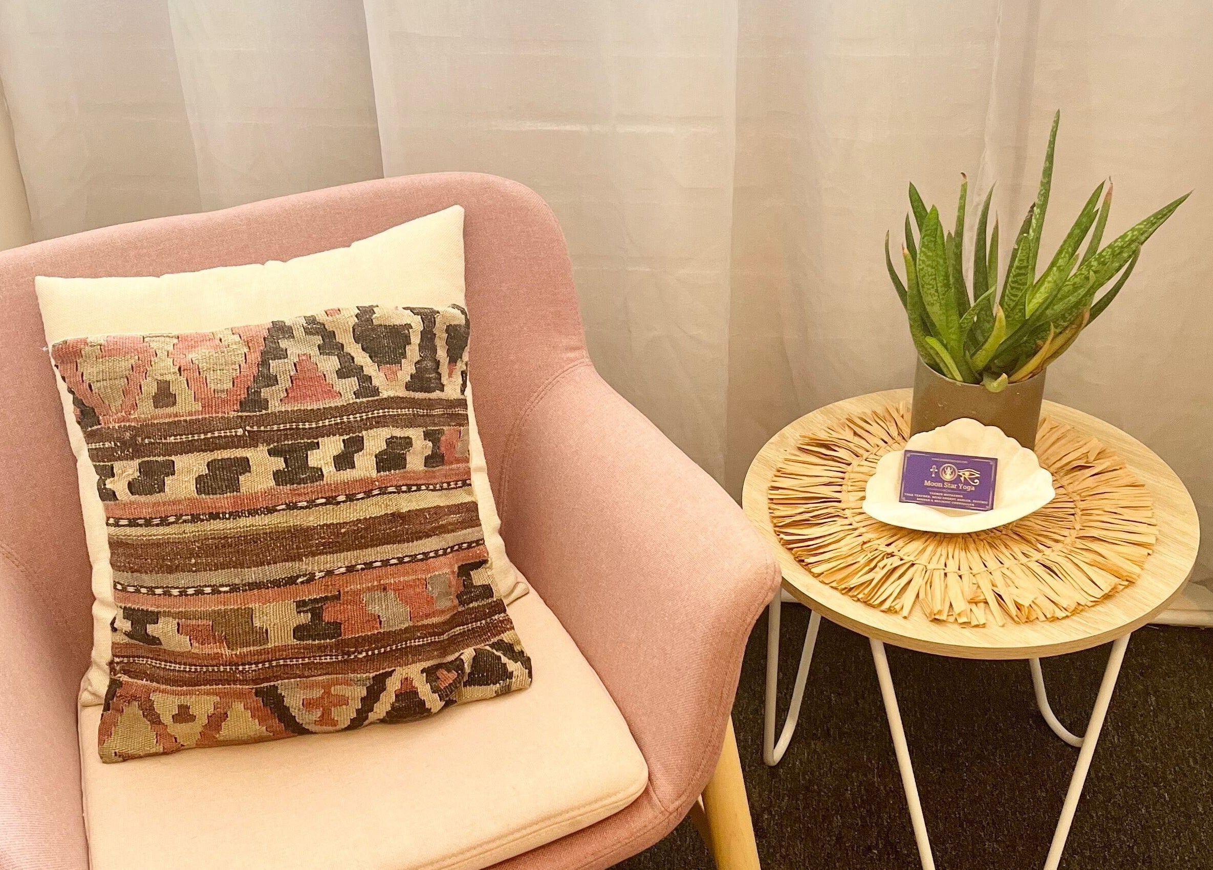 Comfortable seating with accent pillow and plant at Moon Star Yoga, Mona Vale, New South Wales, AU.