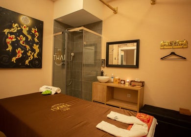 Relajante sala de masajes en Thai Spa Massage Alura, Barcelona, Catalunya, ES, con arte dorado y decoración zen.