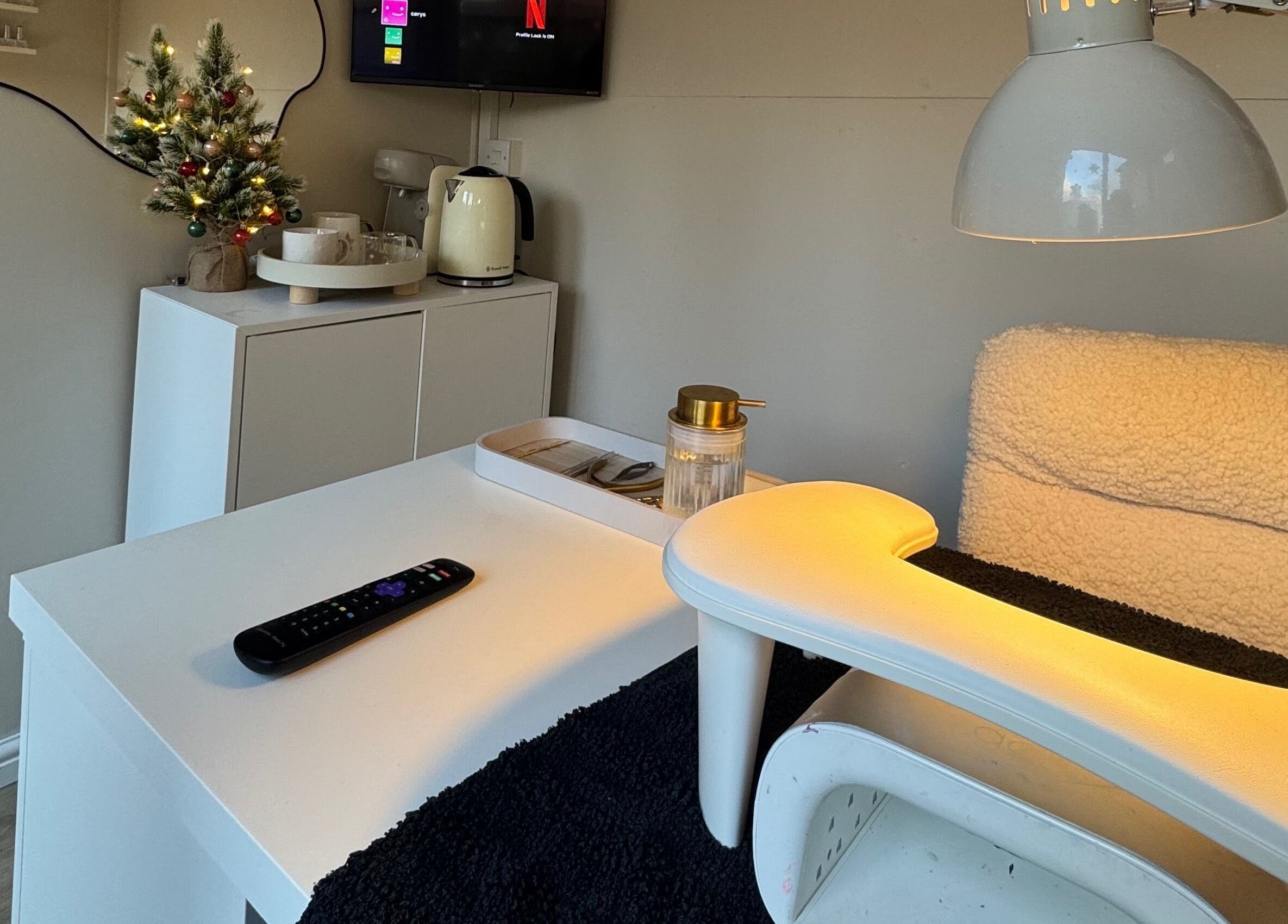 Warm nail station setup at By Cerys Nails in Warrington, England, GB with soft lighting and festive decor.