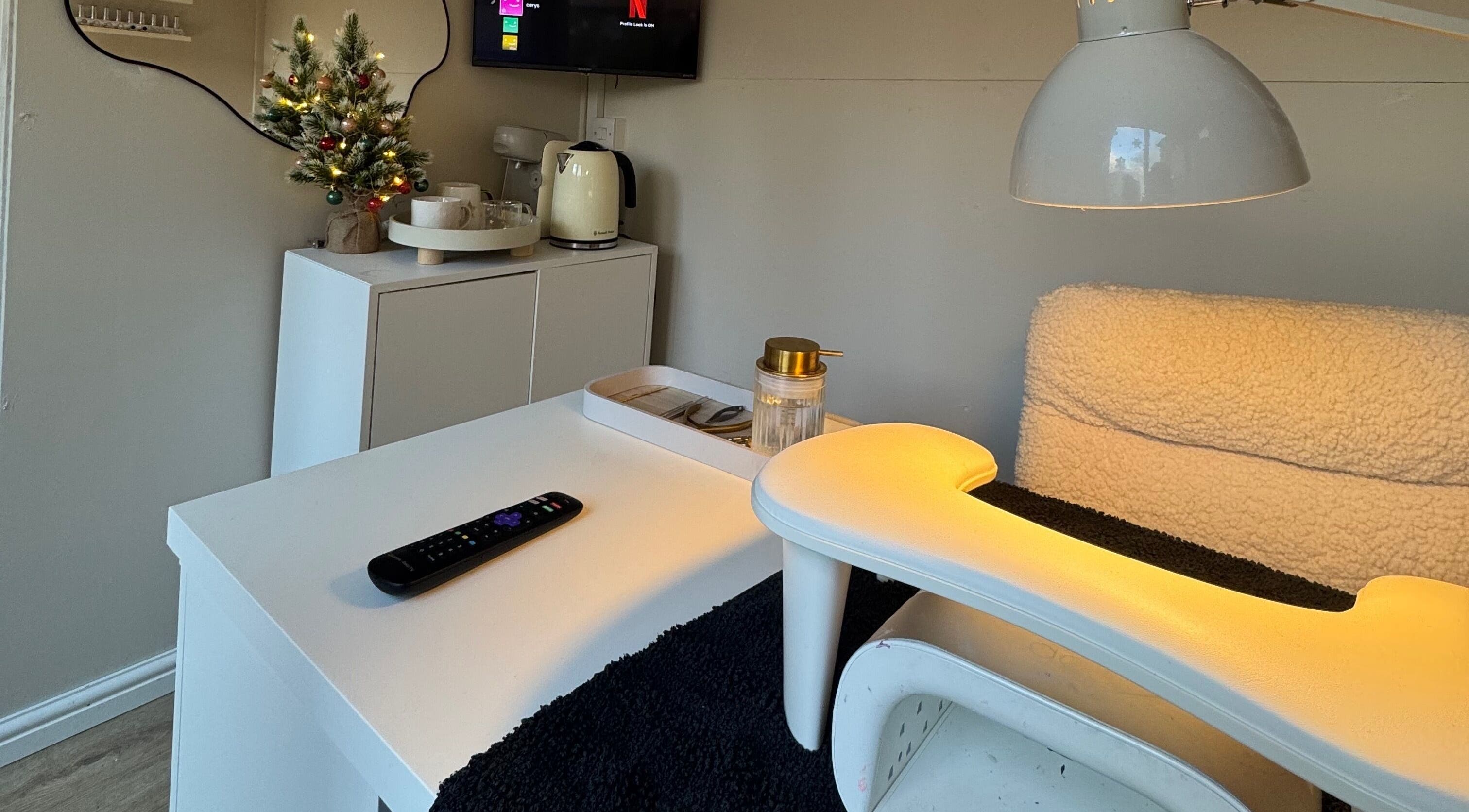 Warm nail station setup at By Cerys Nails in Warrington, England, GB with soft lighting and festive decor.