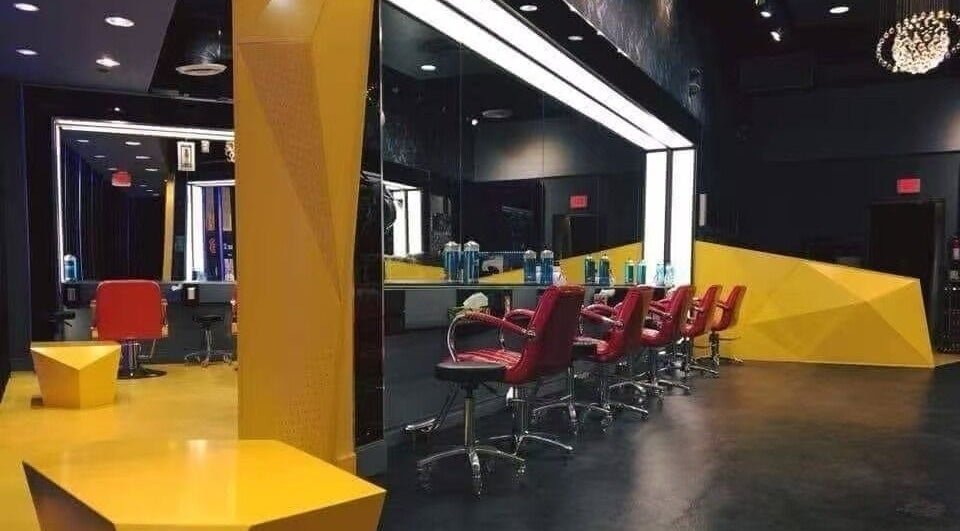 Modern interior of Air Plus Hair Salon at Metrotown, Burnaby, British Columbia, CA with stylish decor and red chairs.