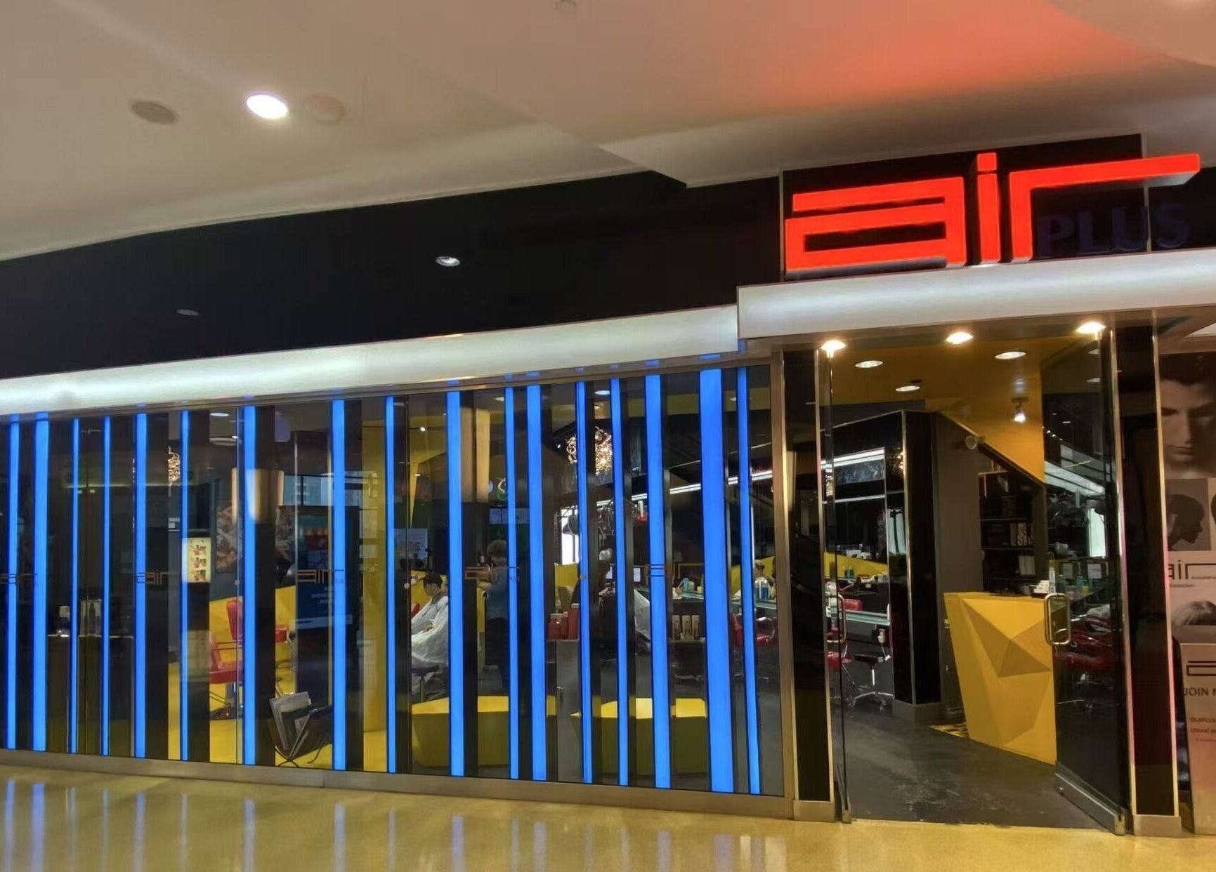 Air Plus Hair Salon at Metrotown, Burnaby, BC, showing a modern exterior with bright lights.