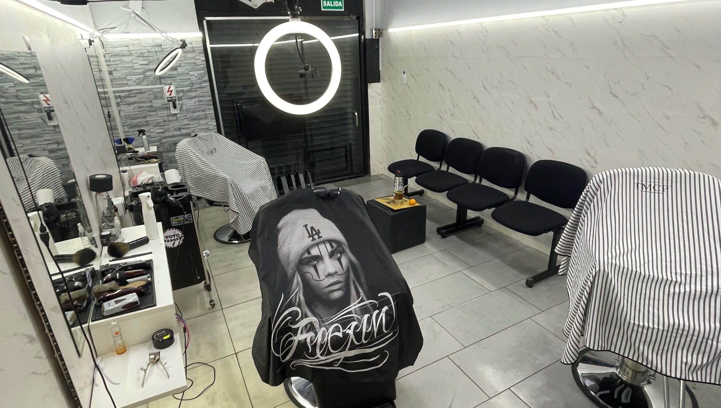 Interior moderno de Toto Barber en San Andres, Provincia De Buenos Aires, AR, con sillas elegantes y herramientas estilísticas.