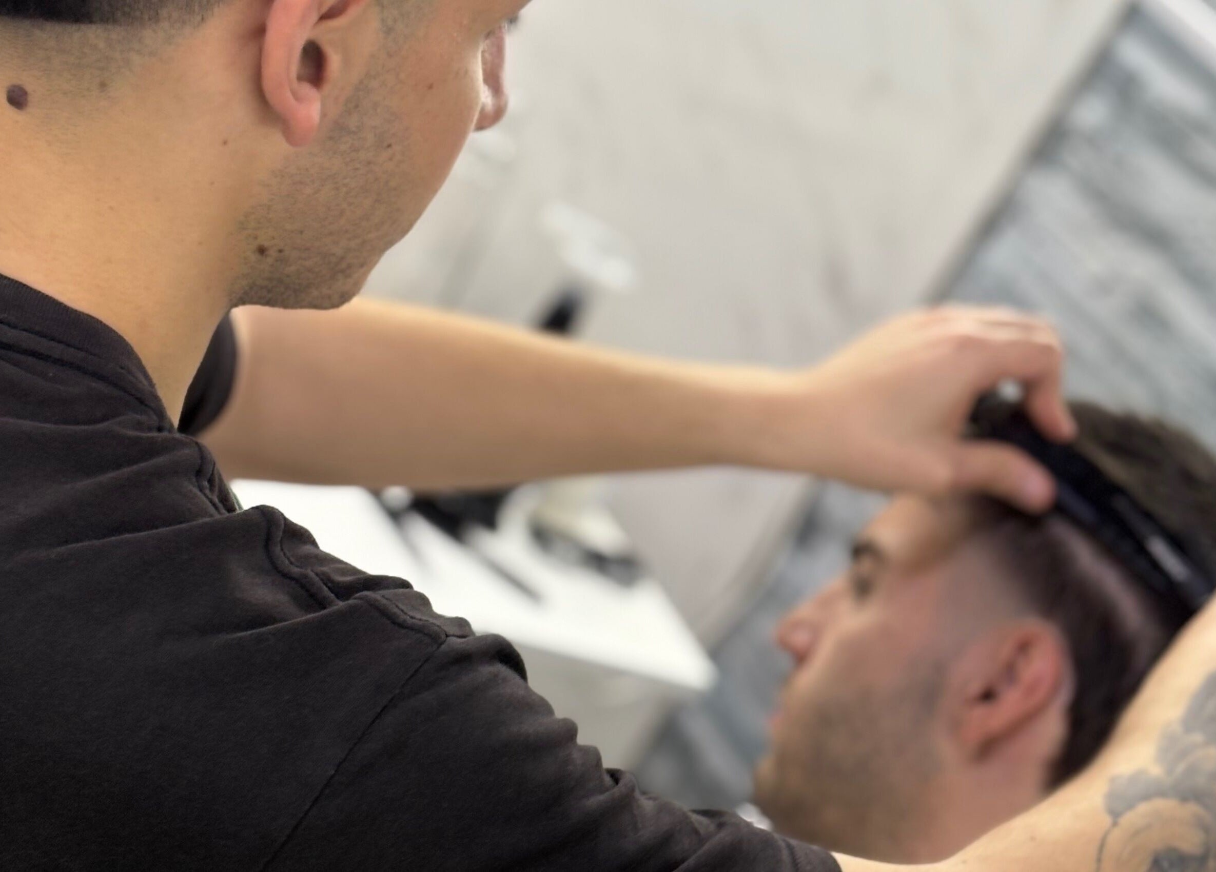 Barbero trabajando en corte de pelo en Toto Barber, San Andres, Provincia De Buenos Aires, AR, con atención al detalle.