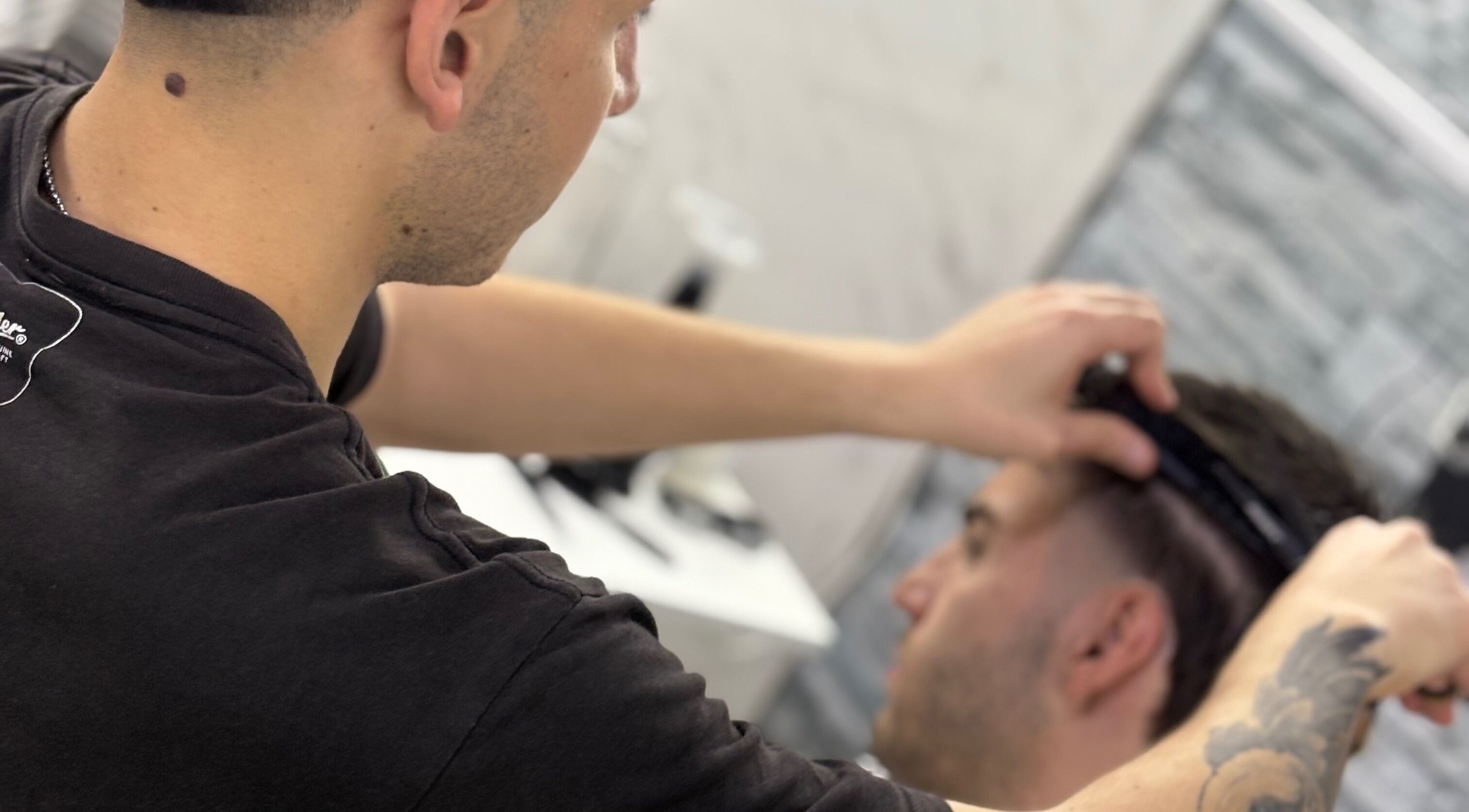Barbero trabajando en corte de pelo en Toto Barber, San Andres, Provincia De Buenos Aires, AR, con atención al detalle.