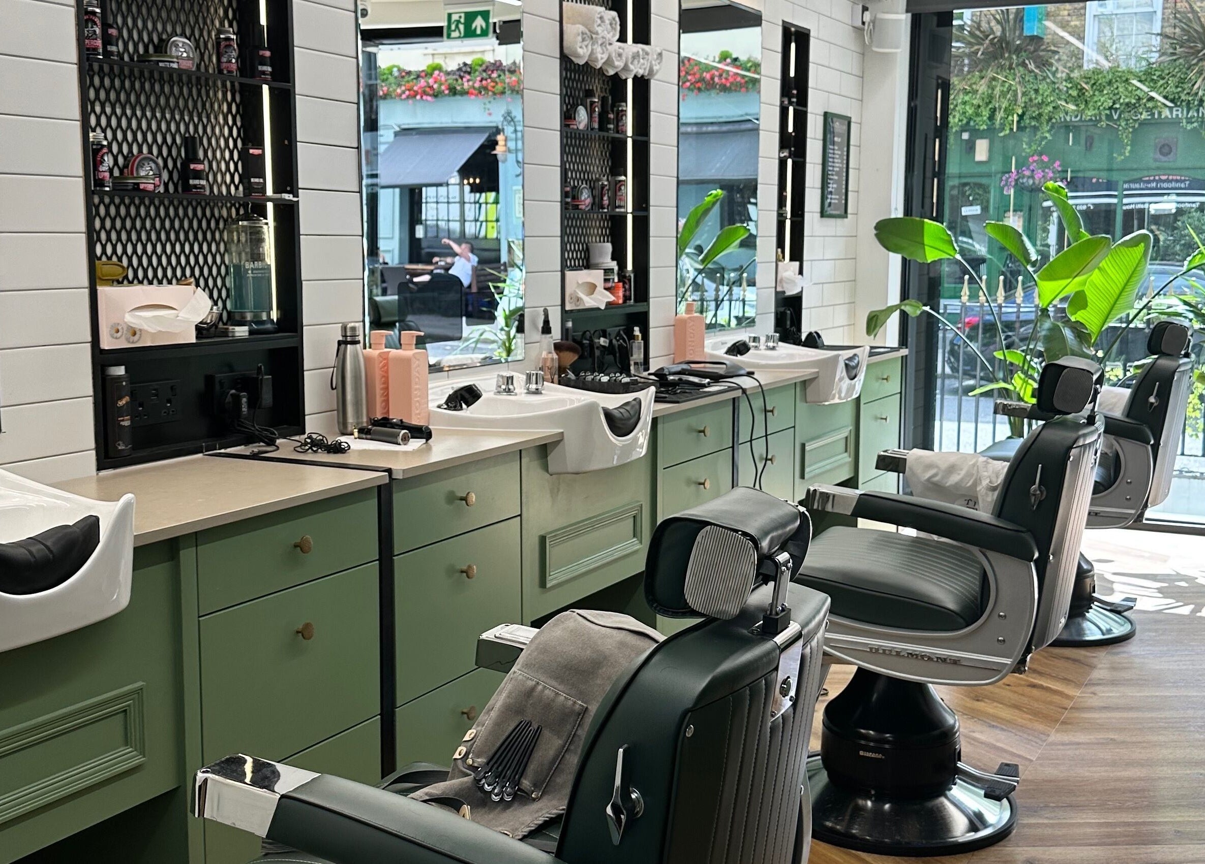 Stylish barber chairs and mirrors at The Axe Club - Euston in London, England, GB.