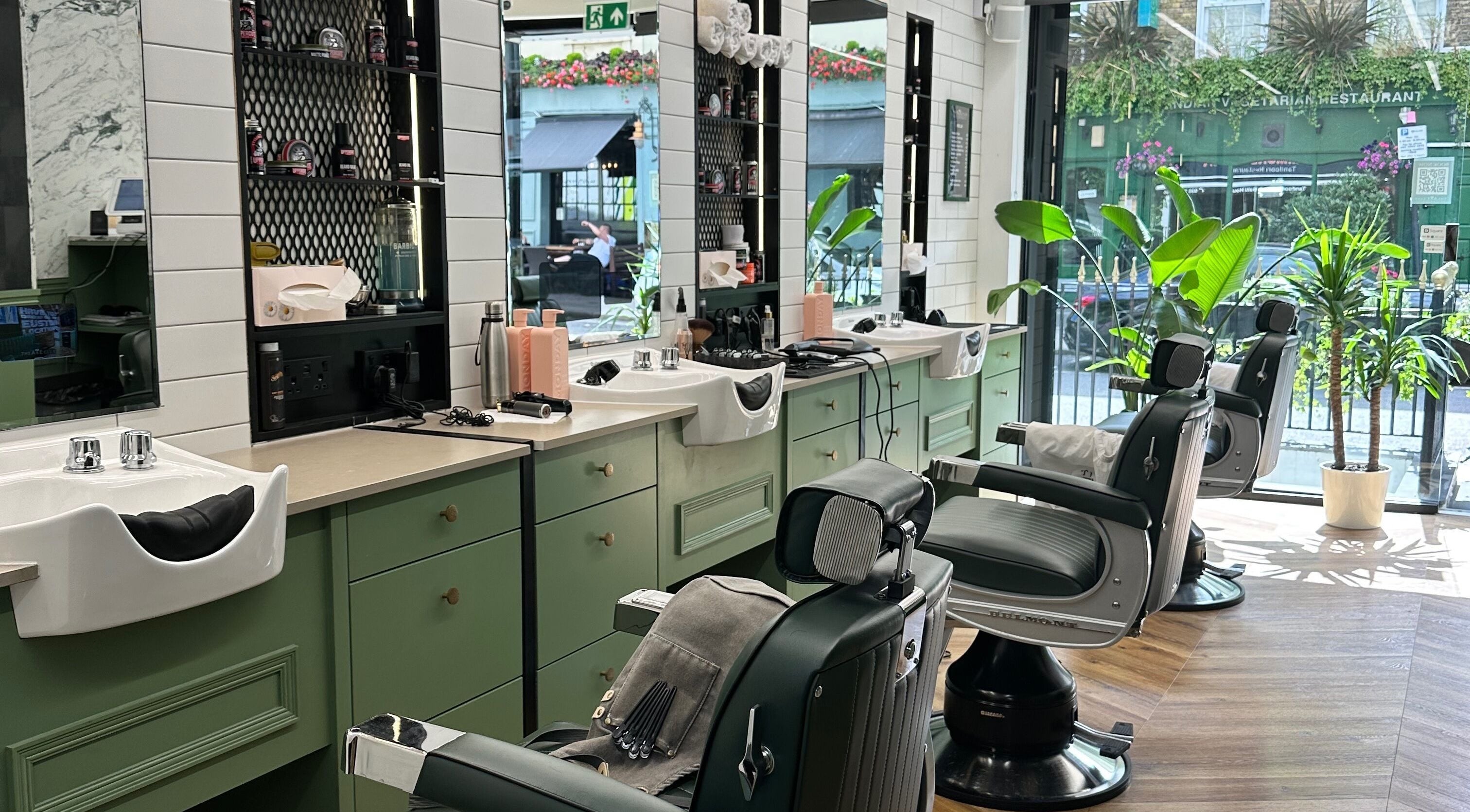 Stylish barber chairs and mirrors at The Axe Club - Euston in London, England, GB.