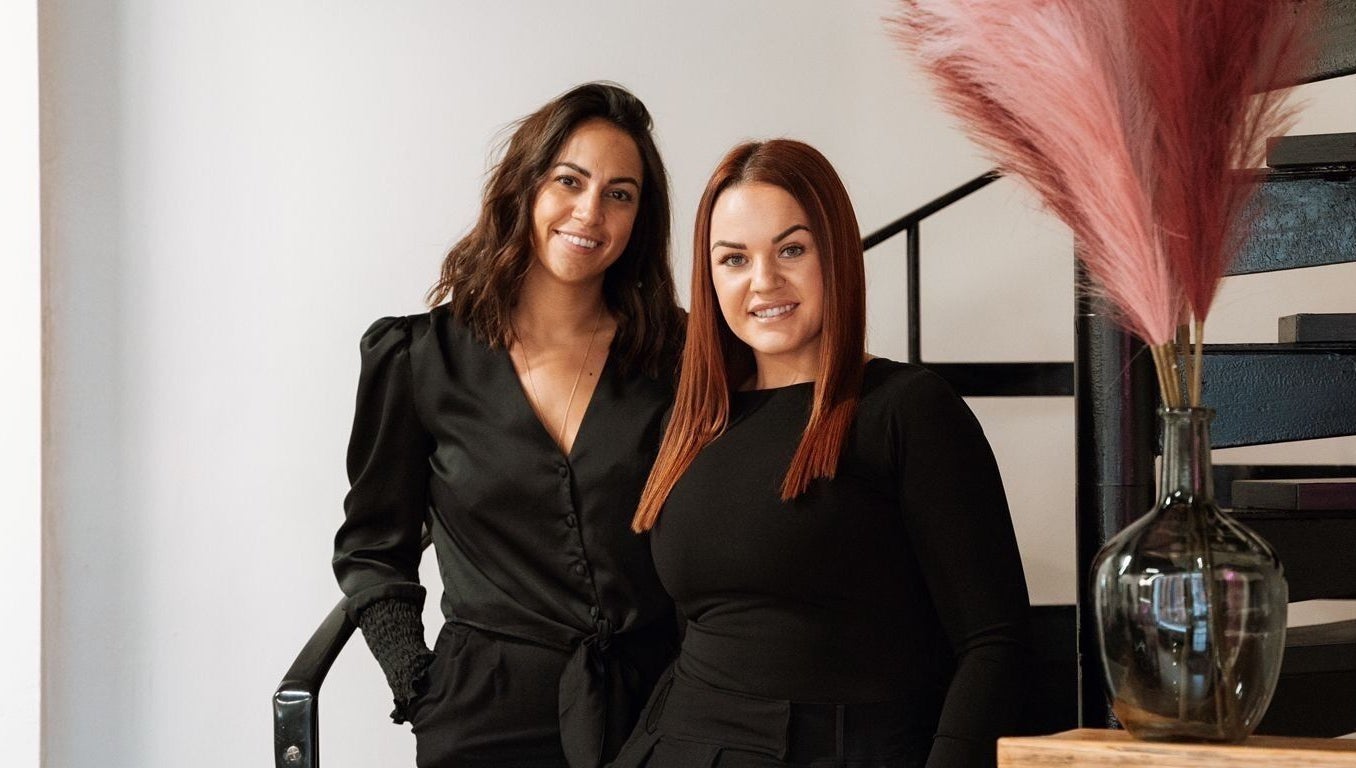 Two women smiling inside The Brow Co., Loughborough, England, GB, showcasing a chic boutique ambiance.