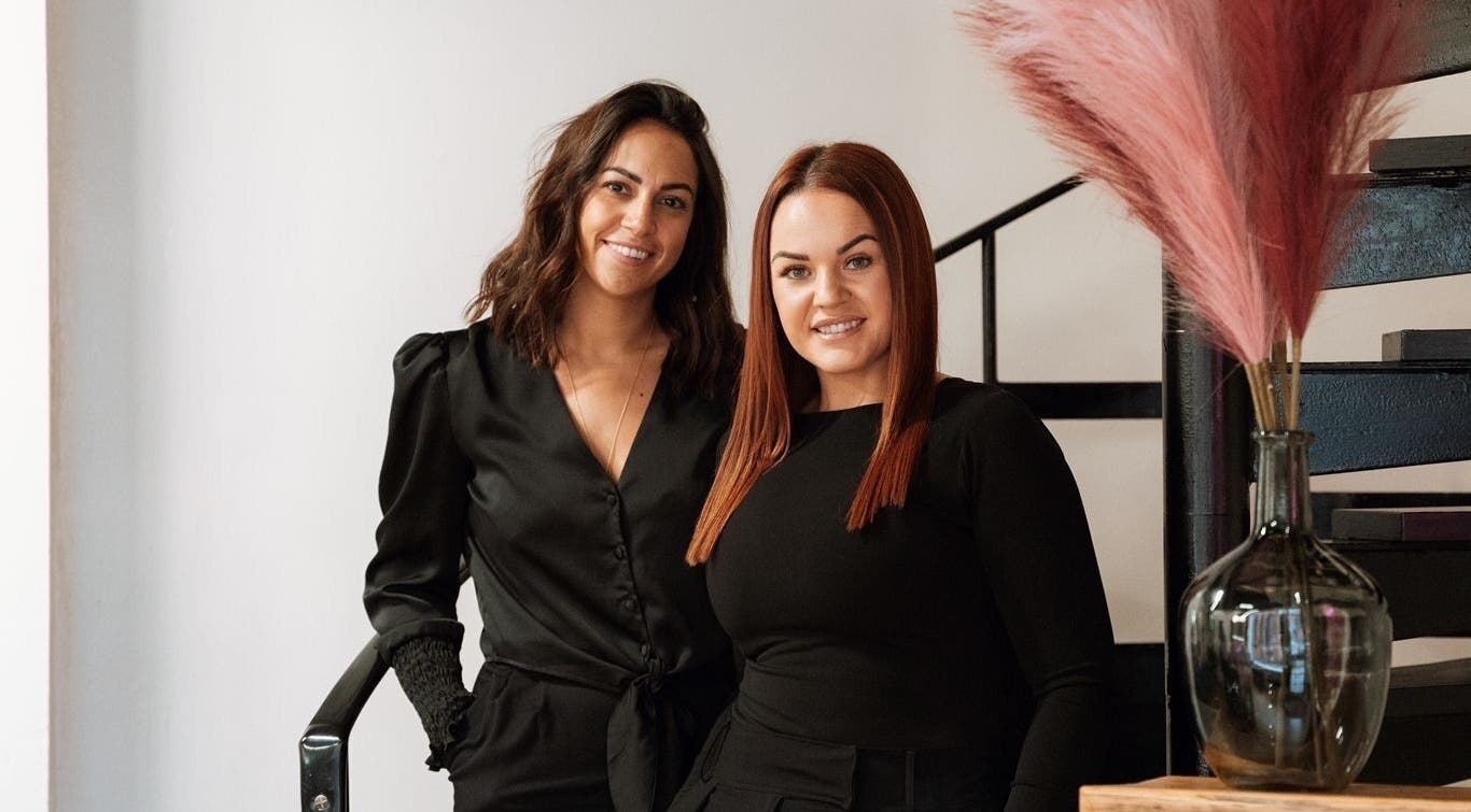 Two women smiling inside The Brow Co., Loughborough, England, GB, showcasing a chic boutique ambiance.