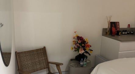 Coin détente à All Skins, Paris, Île-de-France, FR avec chaise en bois et bouquet floral.