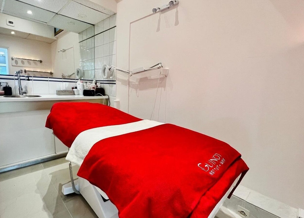 Salle de soins moderne à All Beauty, Paris, Île-de-France, FR avec table rouge.