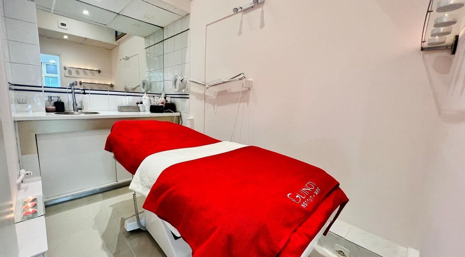 Salle de soins moderne à All Beauty, Paris, Île-de-France, FR avec table rouge.