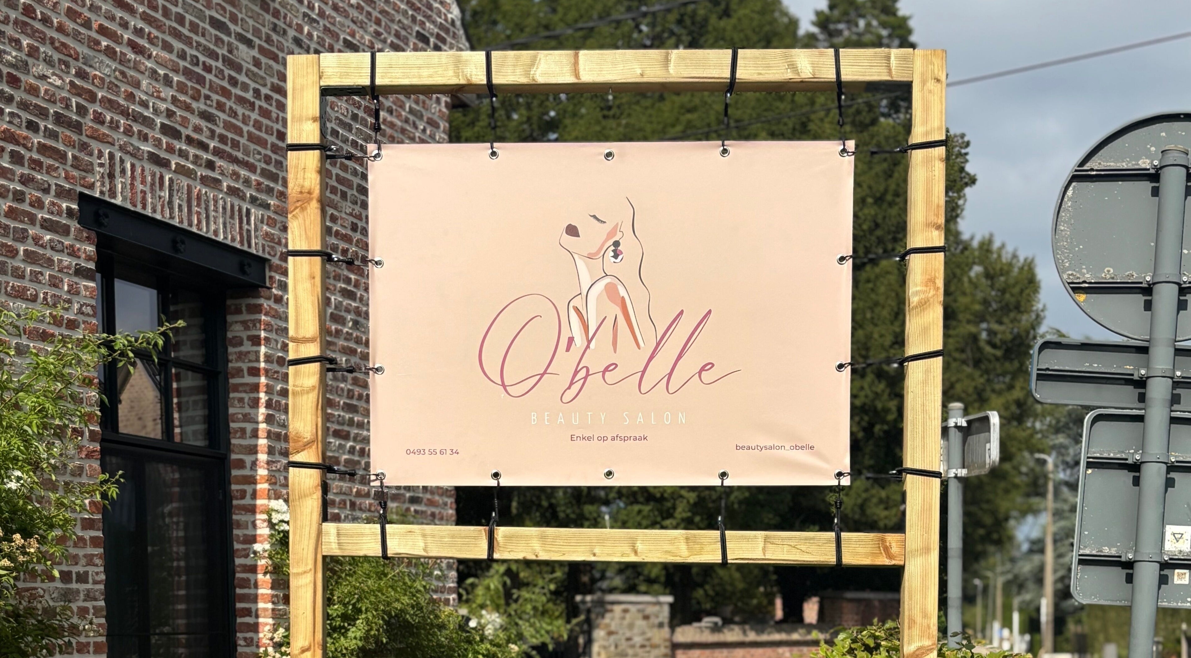 Bord van O'belle schoonheidssalon in Heist-op-den-Berg, Vlaams Gewest, BE, met elegante branding.
