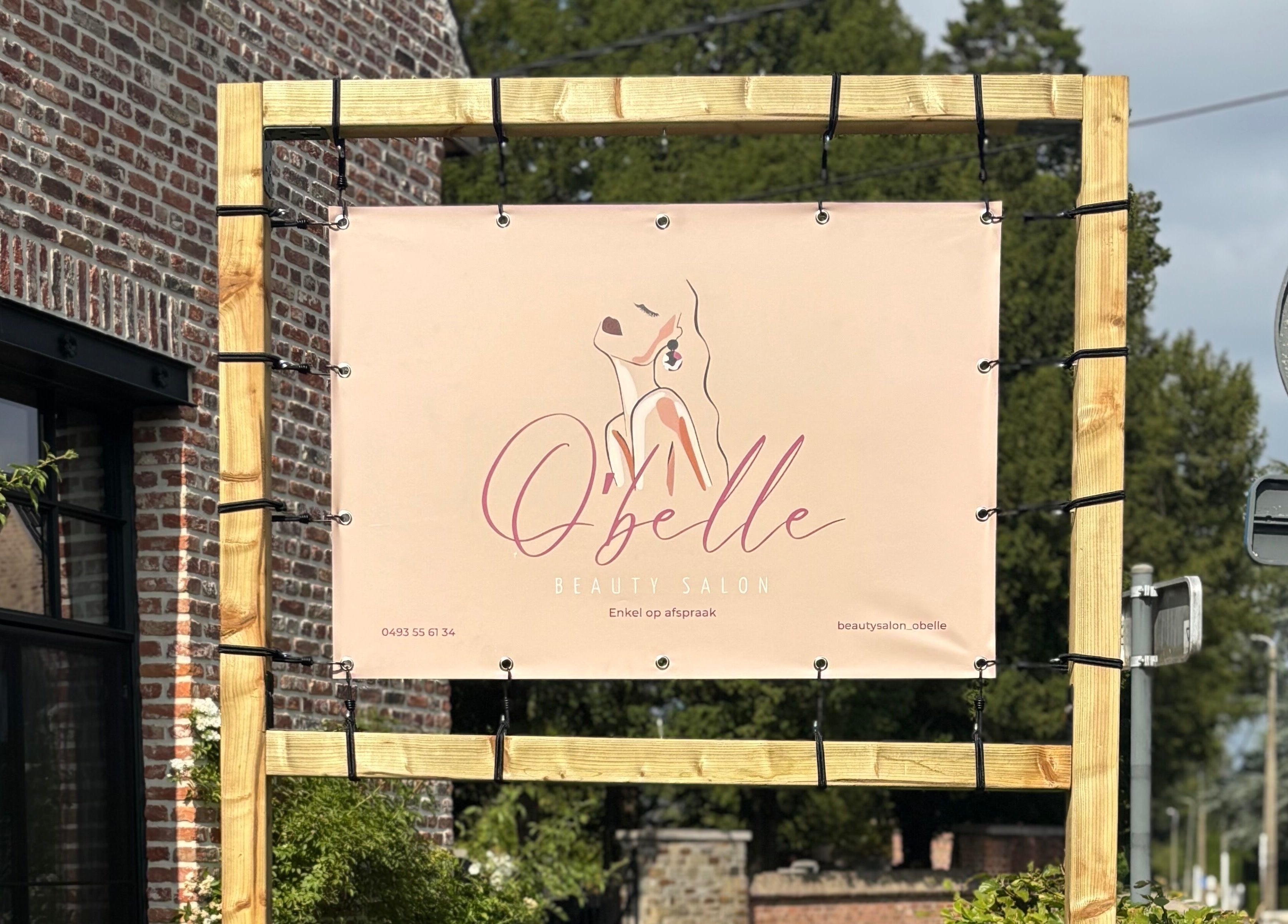 Reclamebord van O'belle aan de muur in Heist-op-den-berg, Vlaams Gewest, BE.