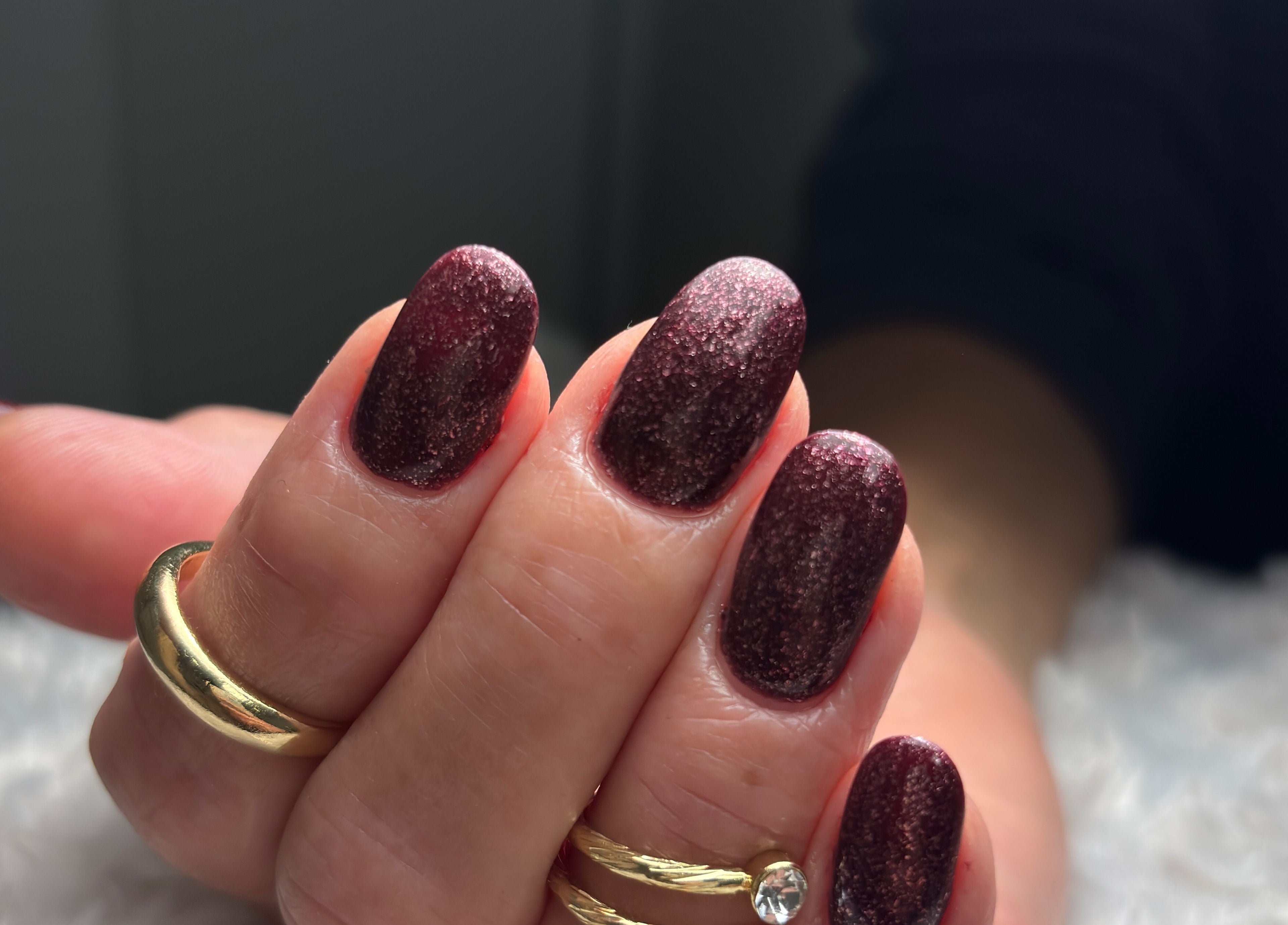 Manucure scintillante à Linsenceenails, Arleux, Hauts-de-France, FR avec vernis sombre et bijoux dorés.