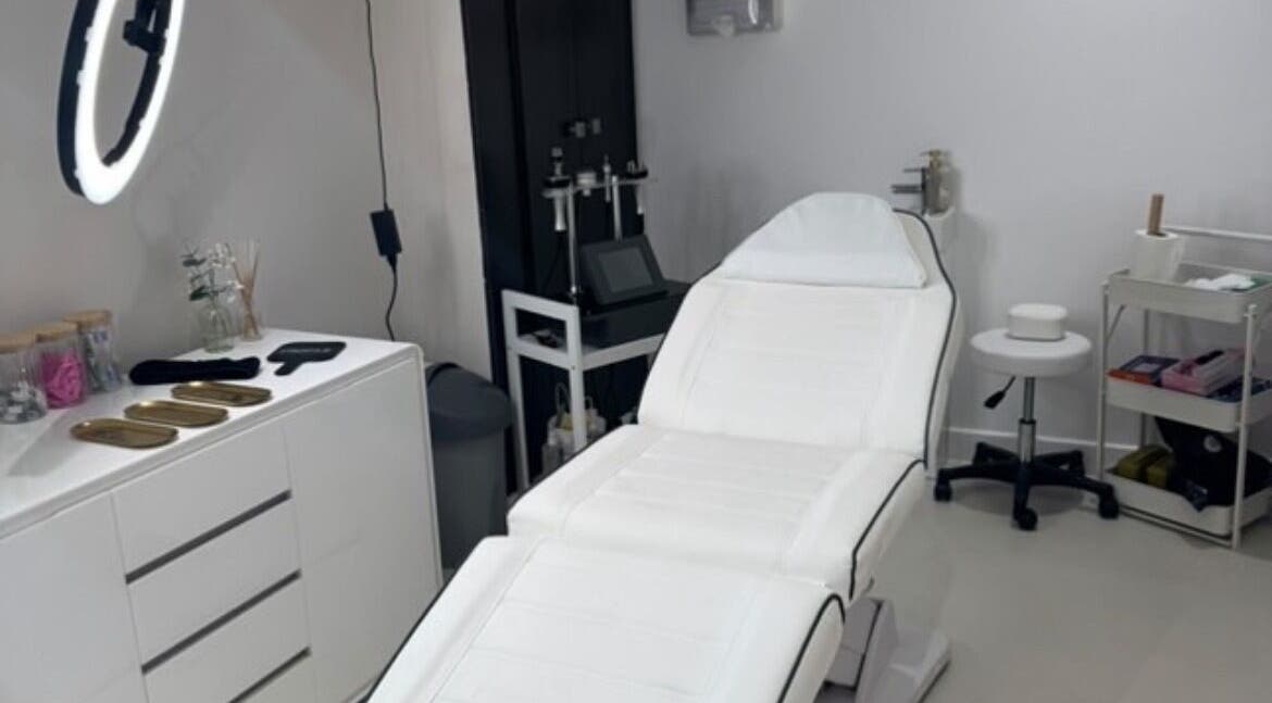 Modern treatment room at Aesthetics By Anna, Southport, England, GB with white therapy bed and tools.