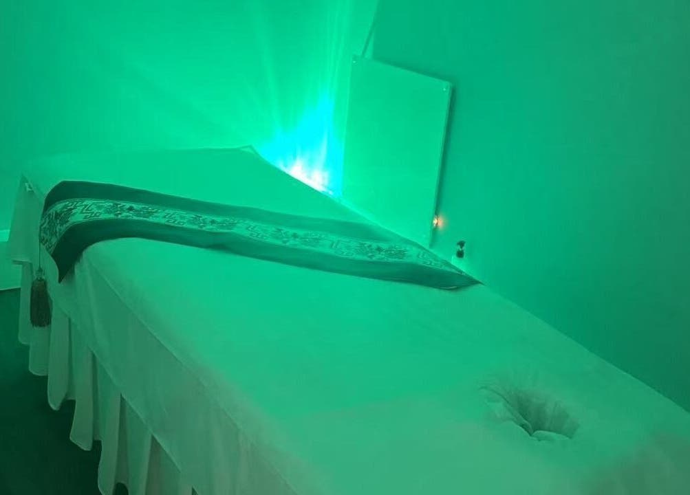 Relaxing massage room with soft green lighting at Yo Spa, London, England, GB.