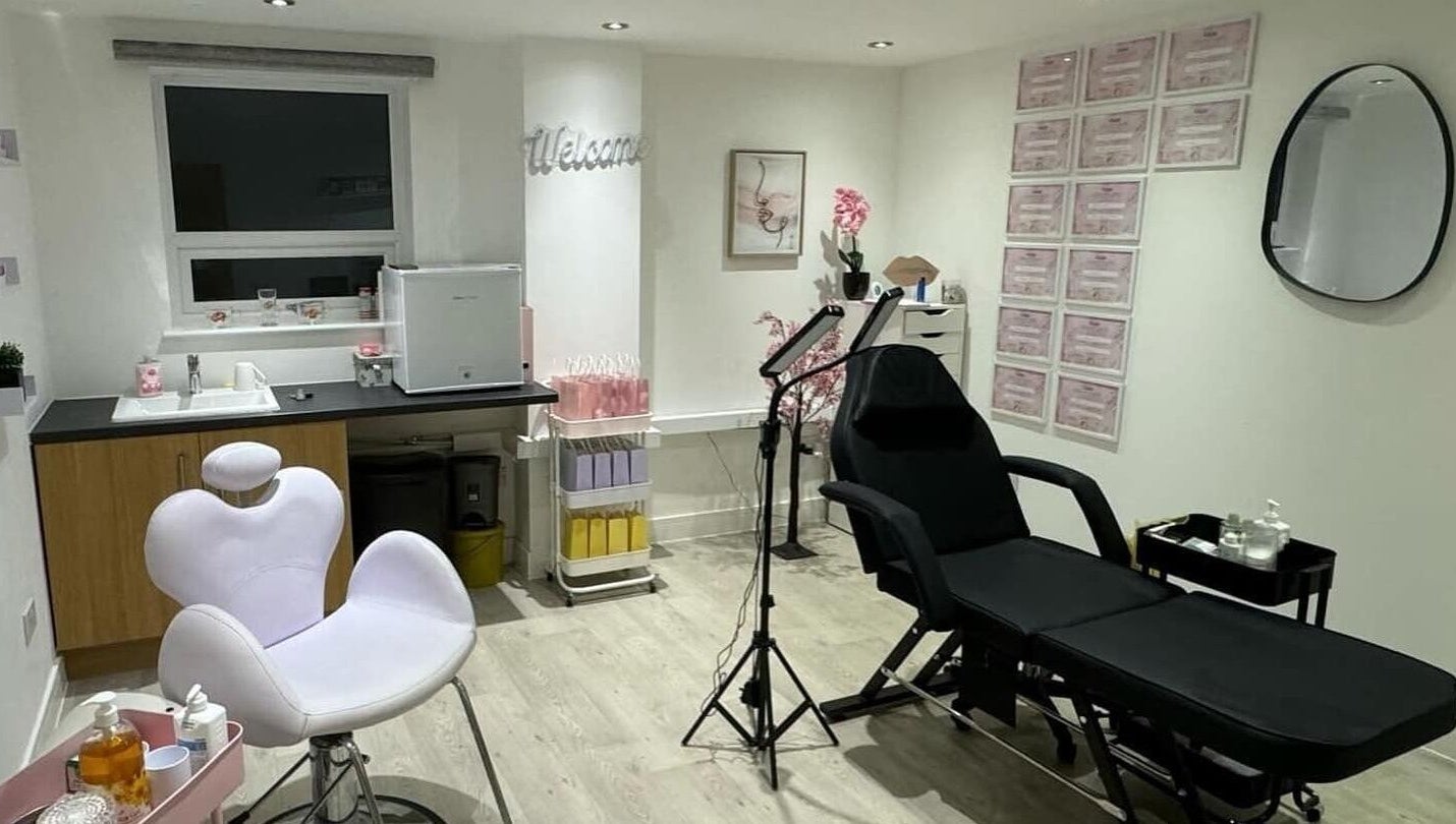 Modern treatment room at B.A Aesthetics, Lyneham, England, GB with white chair and black reclining bed.
