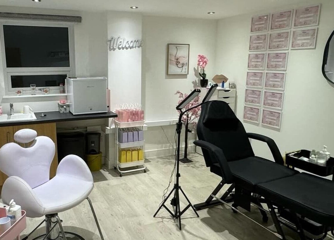 Modern treatment room at B.A Aesthetics, Lyneham, England, GB with white chair and black reclining bed.
