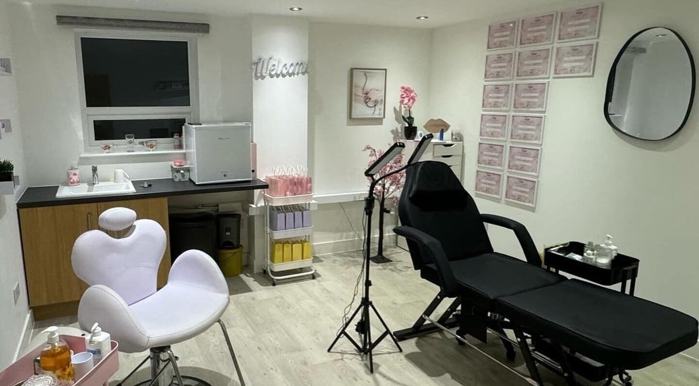 Modern treatment room at B.A Aesthetics, Lyneham, England, GB with white chair and black reclining bed.